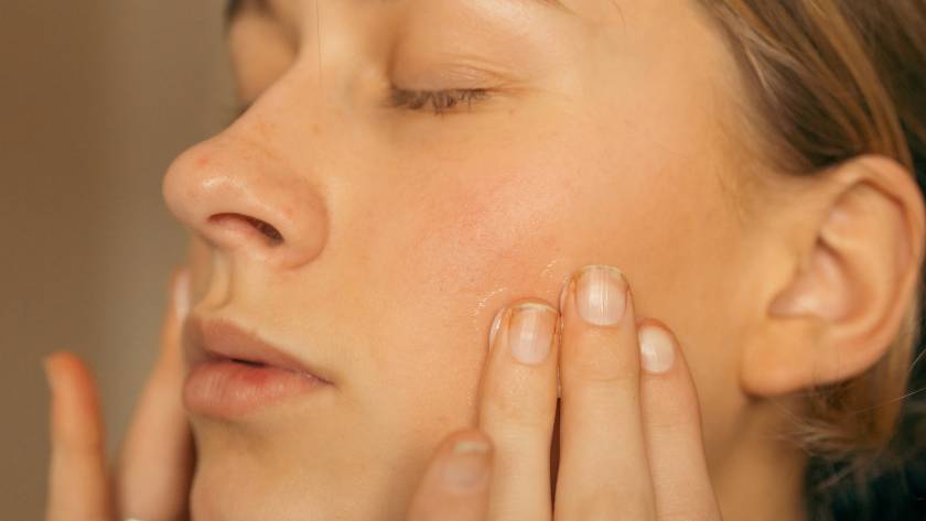 woman feeling her face