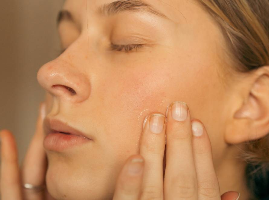 woman feeling her face